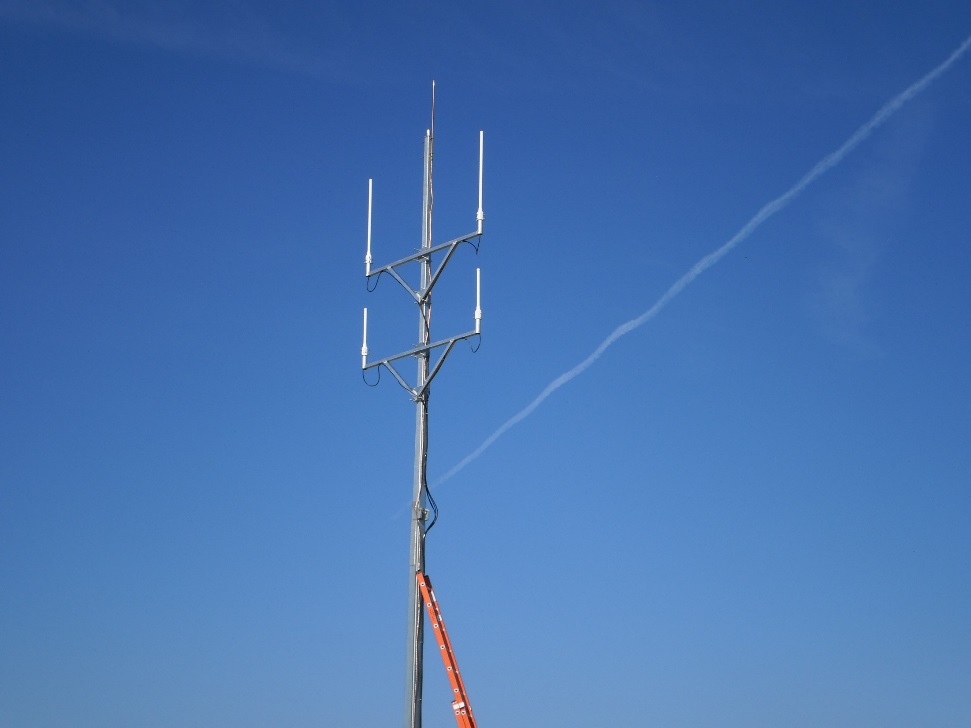 Antenna mast being serviced against a clear sky